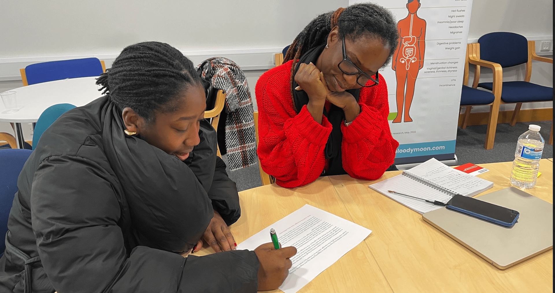 Two women looking at case study